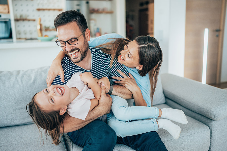 family of three enjoying time together in living room