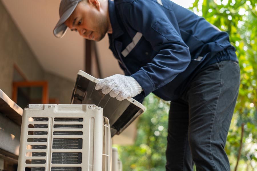 hvac technicians working on outdoor air conditioning unit